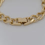 Gold chain bracelet on a light gray background