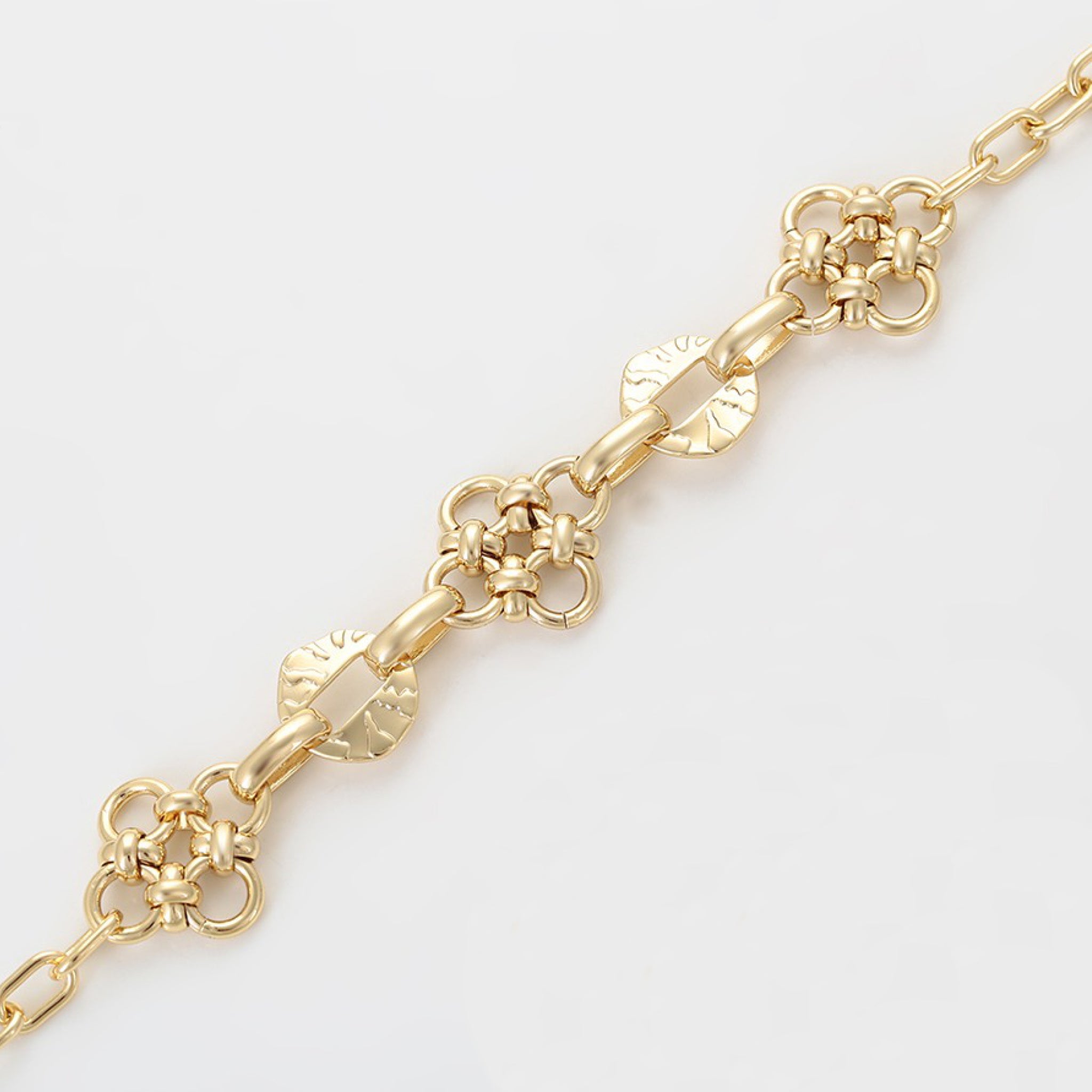 Gold chain bracelet on a light gray background