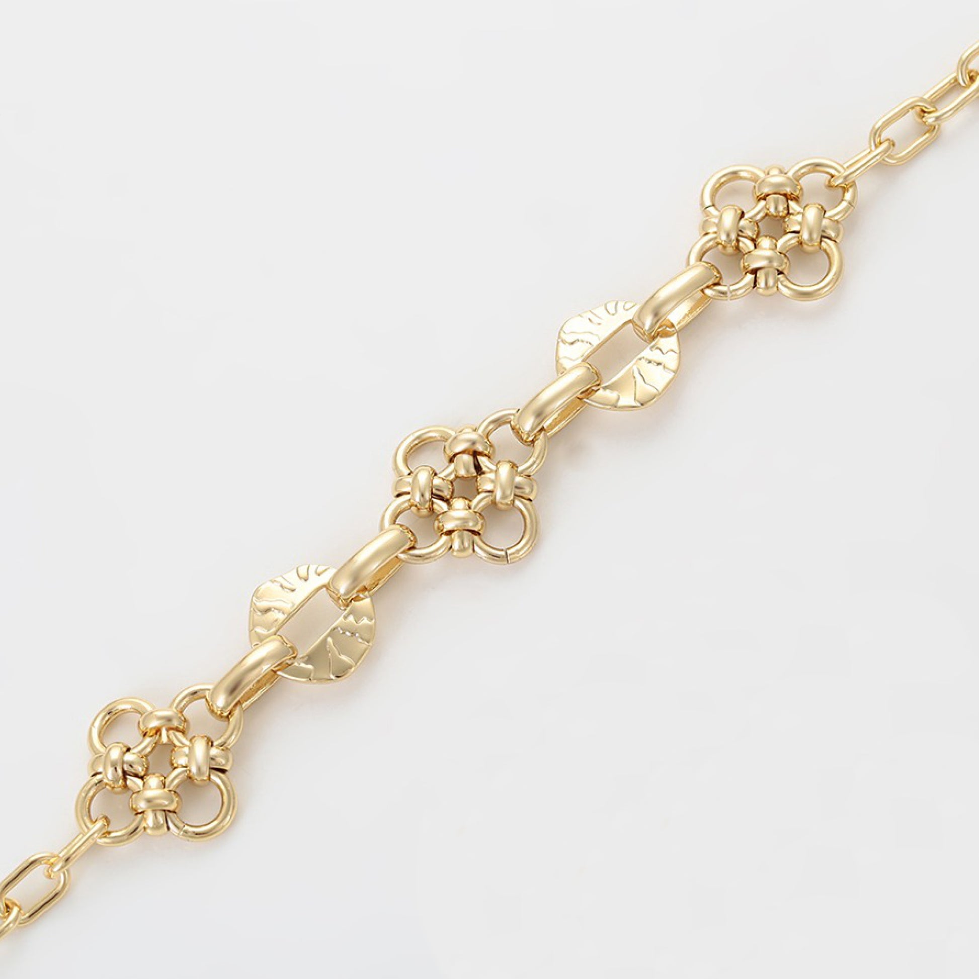 Gold chain bracelet on a light gray background