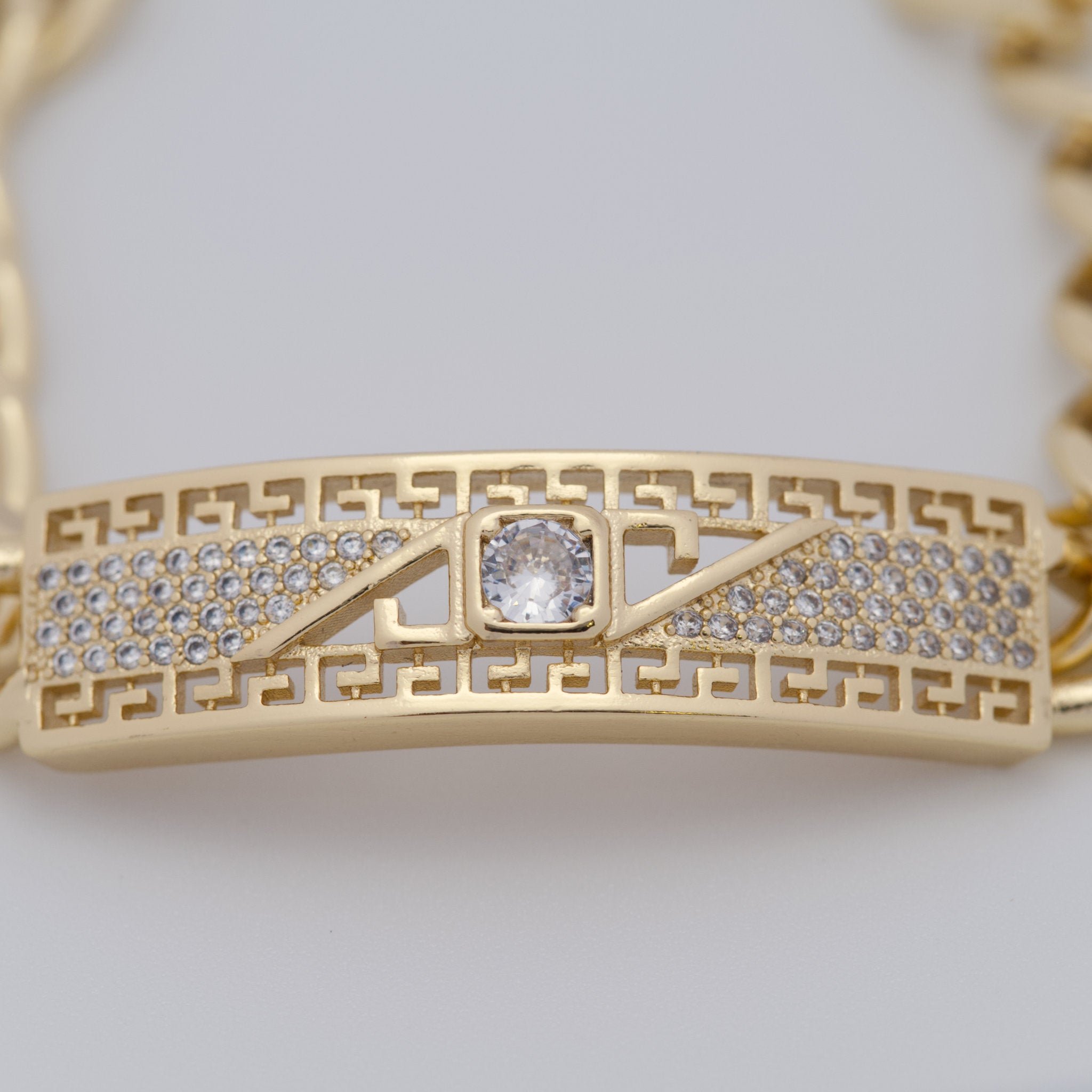 Gold bracelet with diamond accents on a light gray background