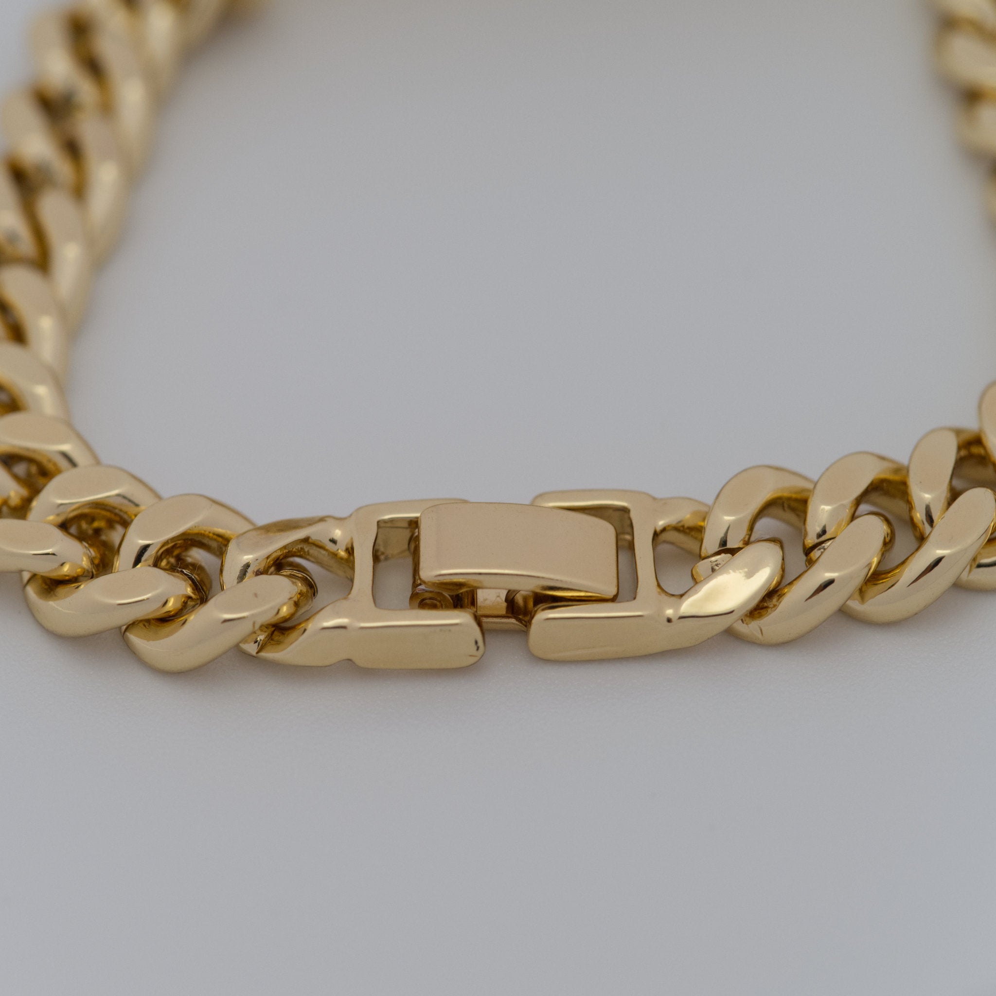 Gold chain necklace on a light gray background