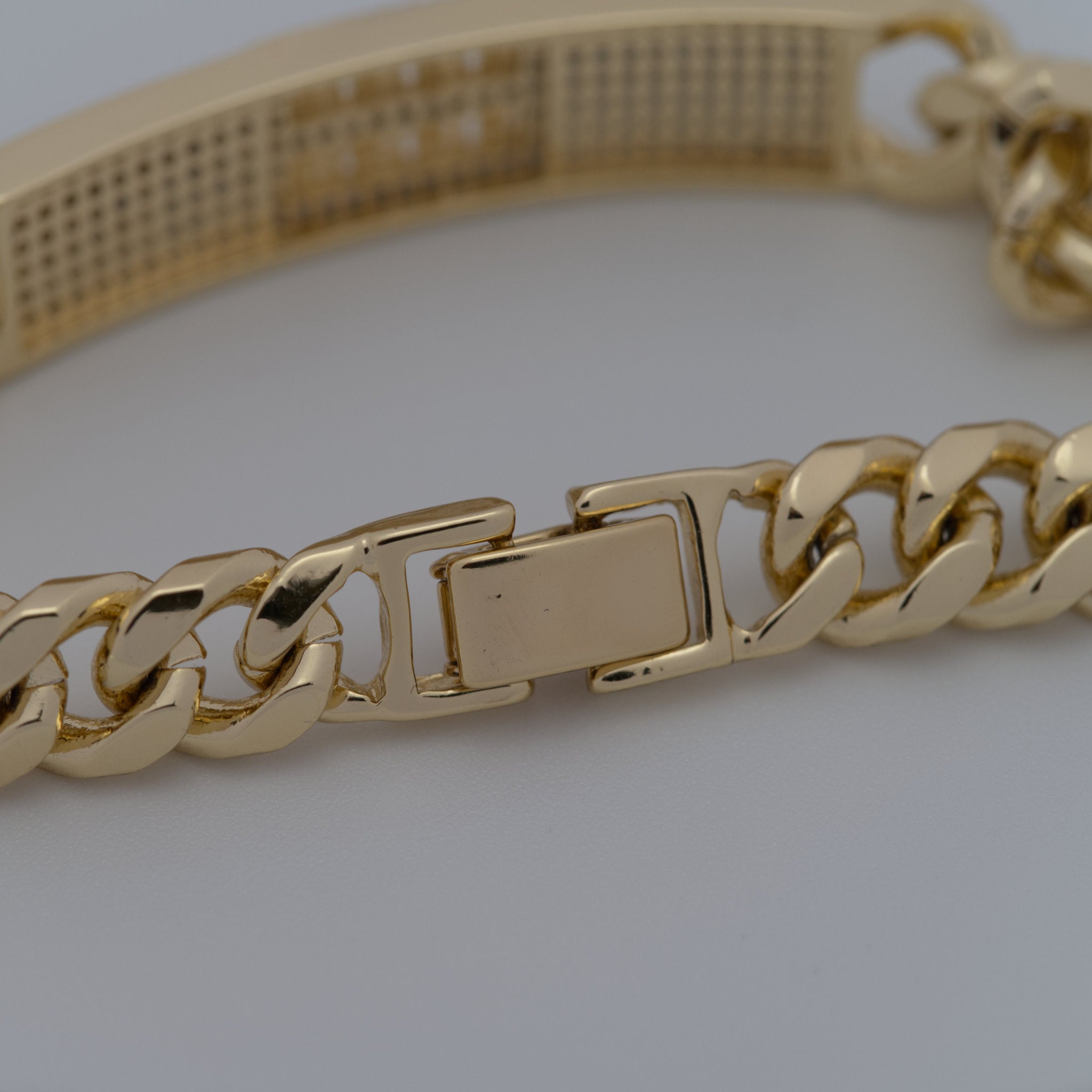 Gold chain bracelet on a light gray background