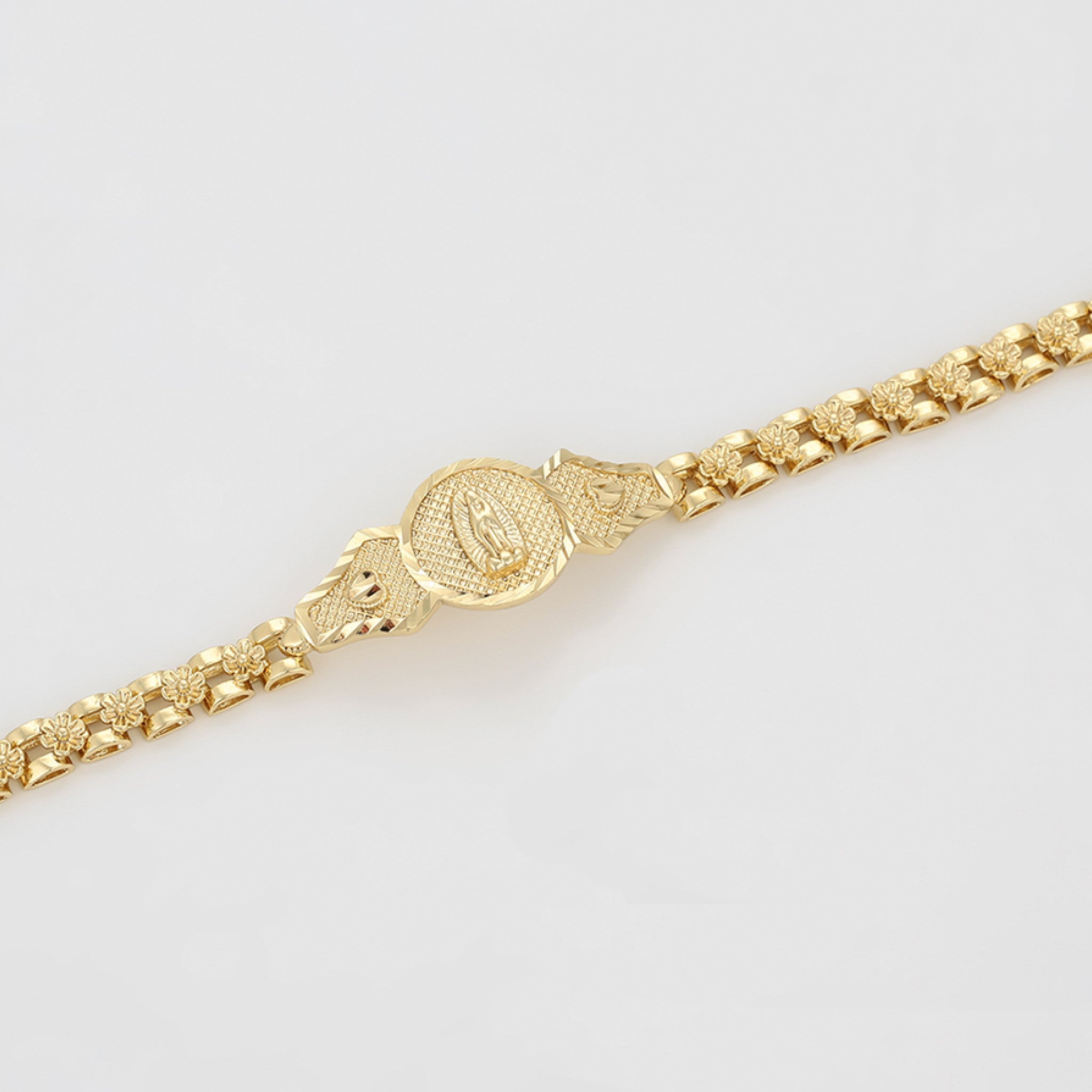 Gold bracelet on a light gray background
