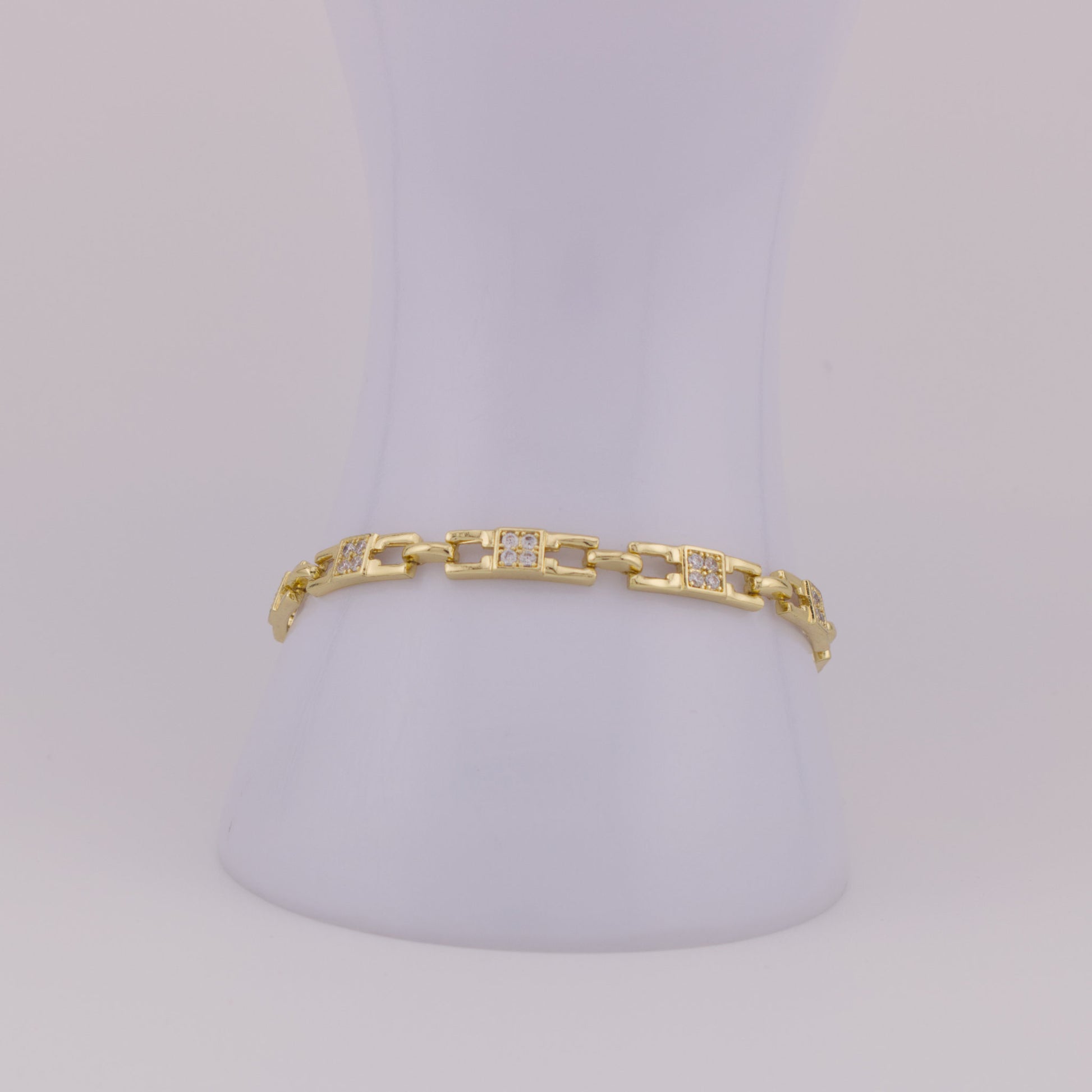 Gold bracelet with diamond accents on a light gray background
