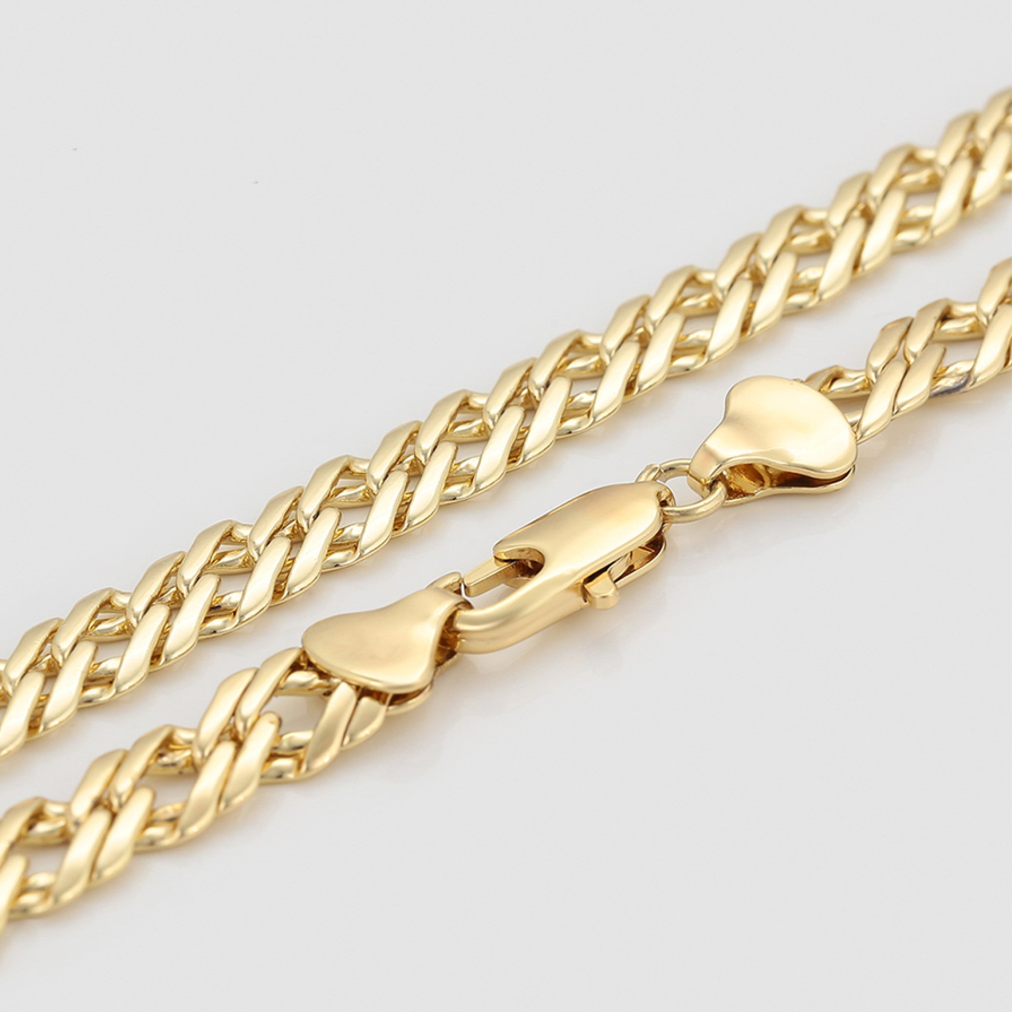 Gold chain necklace on a light gray background