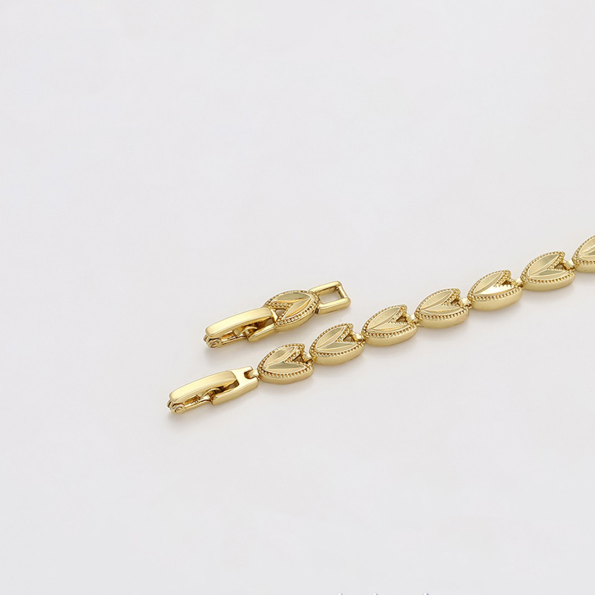 Gold bracelet on a light gray background