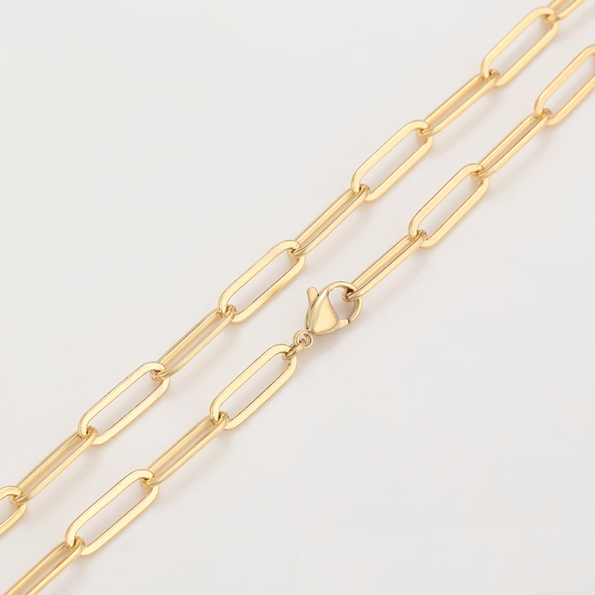 Gold chain necklace on a light gray background