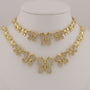 Gold butterfly necklace on a mannequin bust against a neutral background