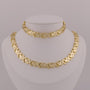 Gold necklace on a mannequin bust against a gray background