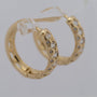 Gold hoop earrings with diamond accents on a light gray background