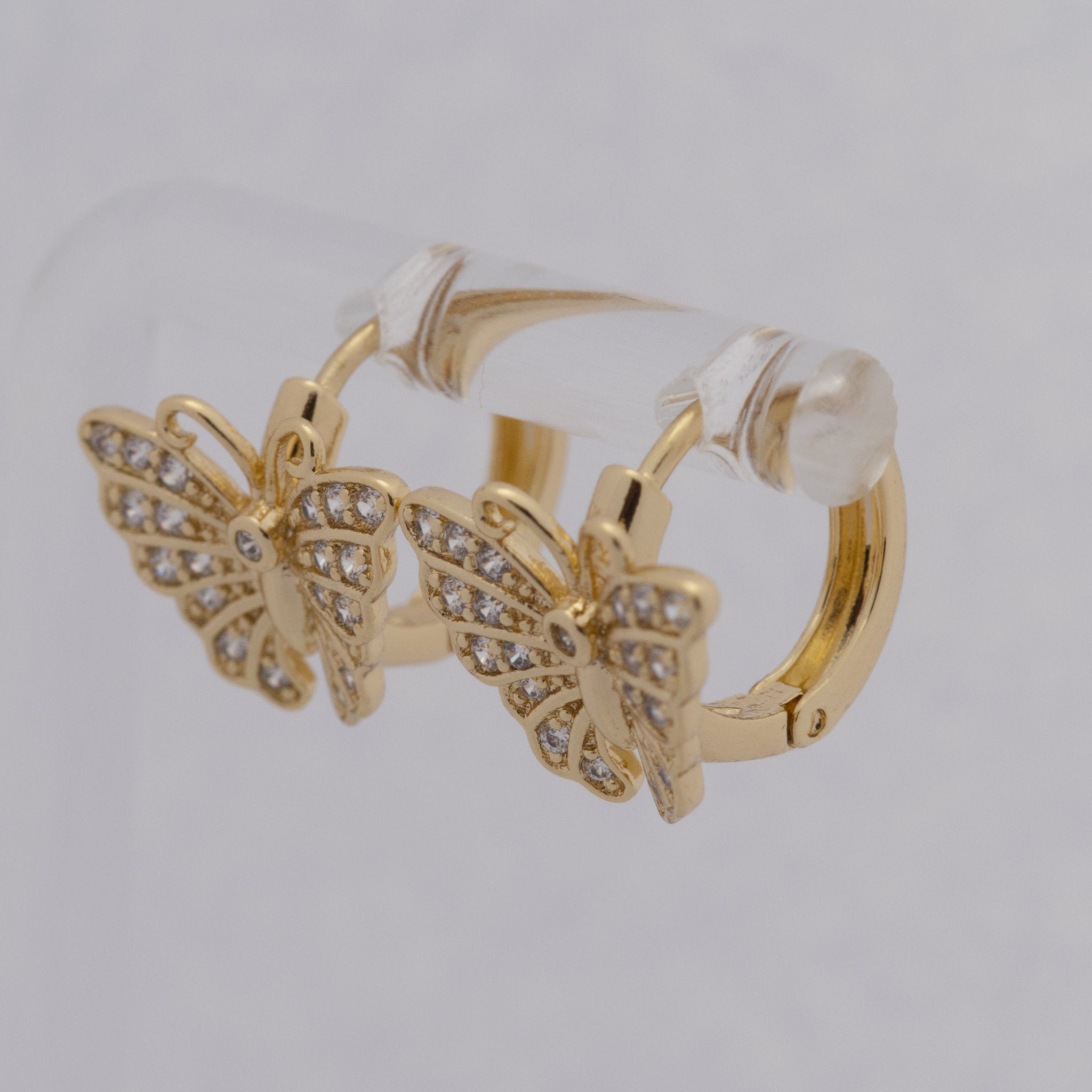 Gold butterfly earrings on a light gray background