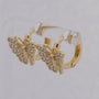 Gold butterfly earrings on a light gray background