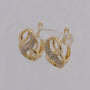 Gold hoop earrings with small diamonds on a light gray background