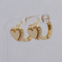 Gold hoop earrings with heart designs on a light gray background