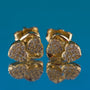 Gold earrings with diamond accents on a blue background