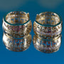 Two gold rings with intricate designs on a blue background