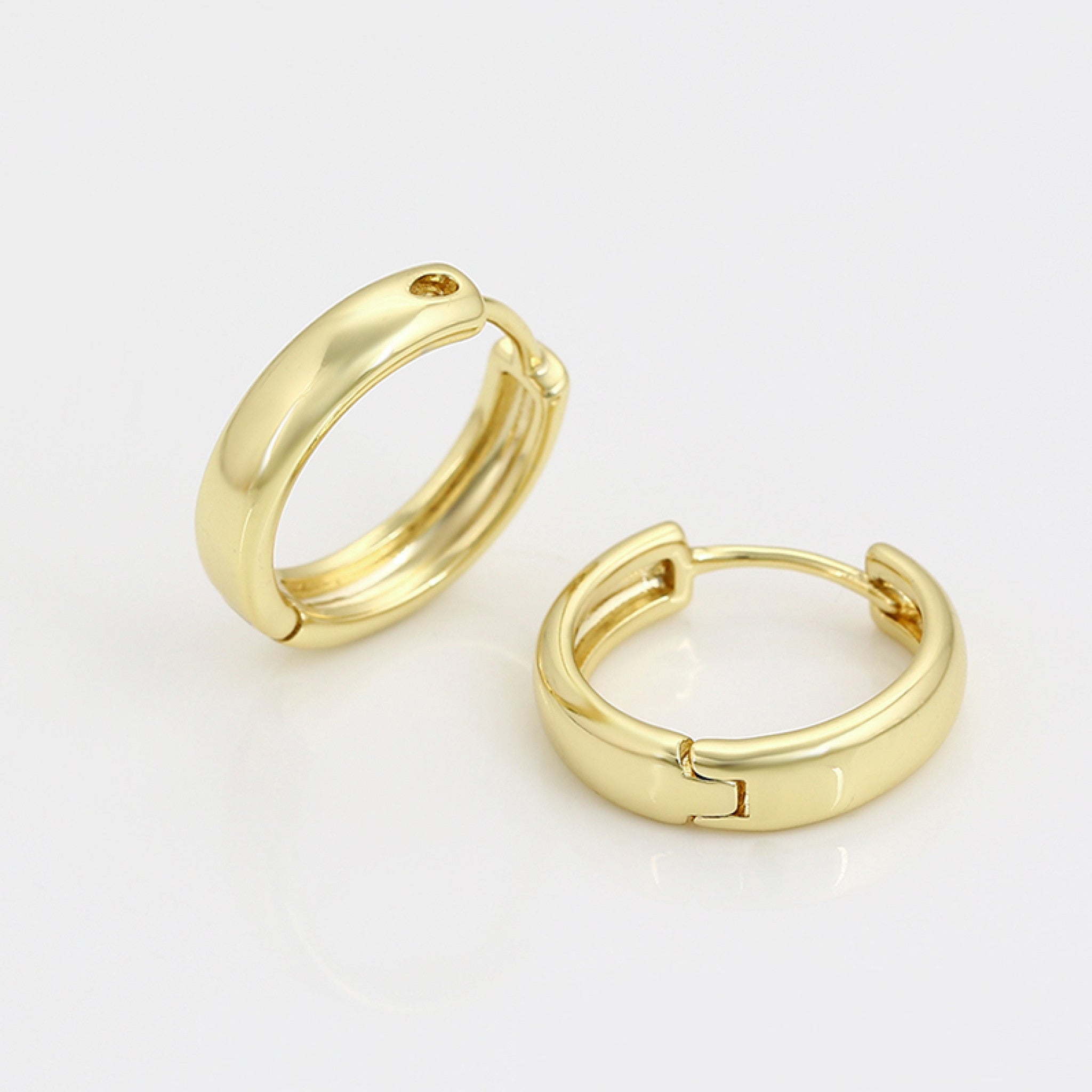 Gold hoop earrings on a light gray background