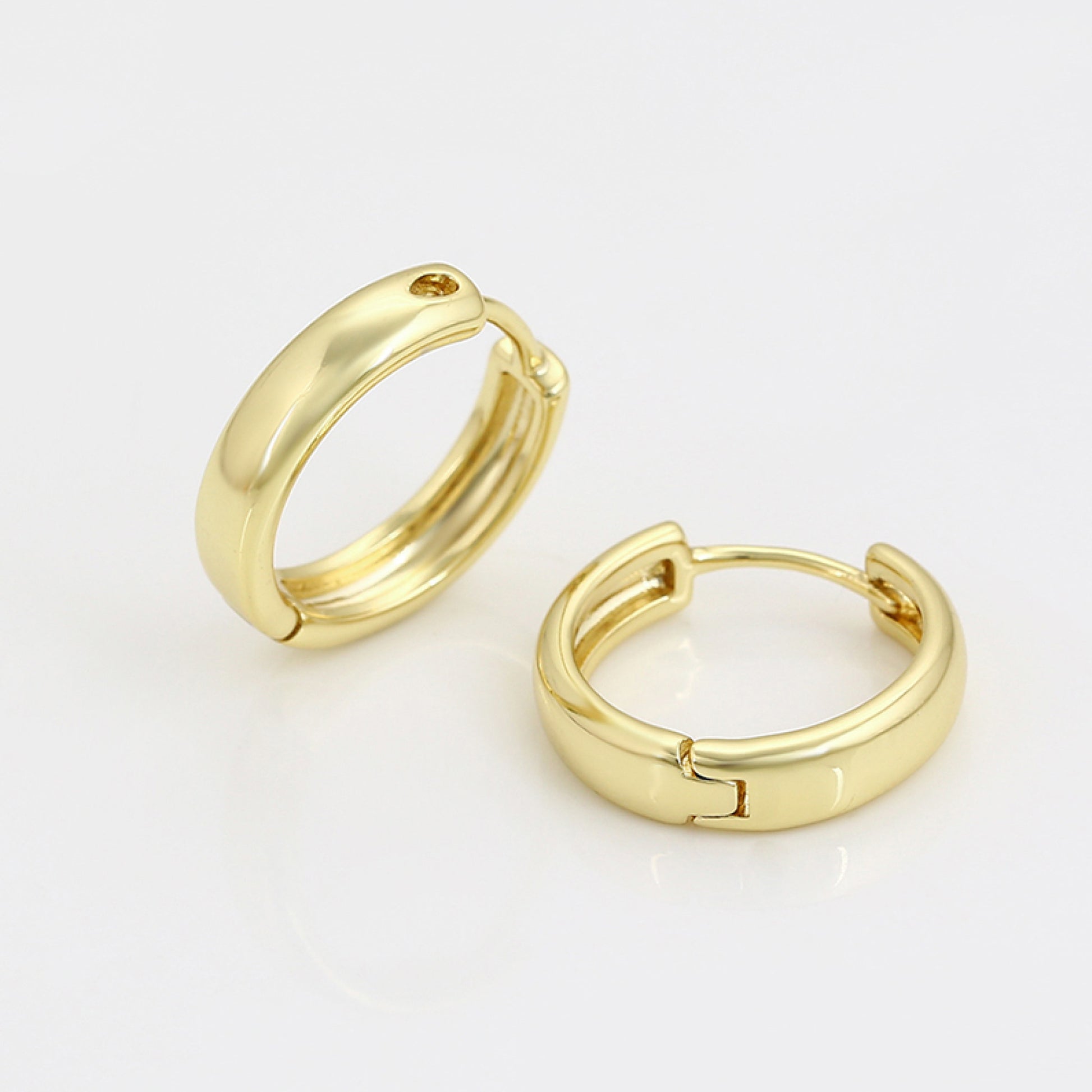 Gold hoop earrings on a light gray background