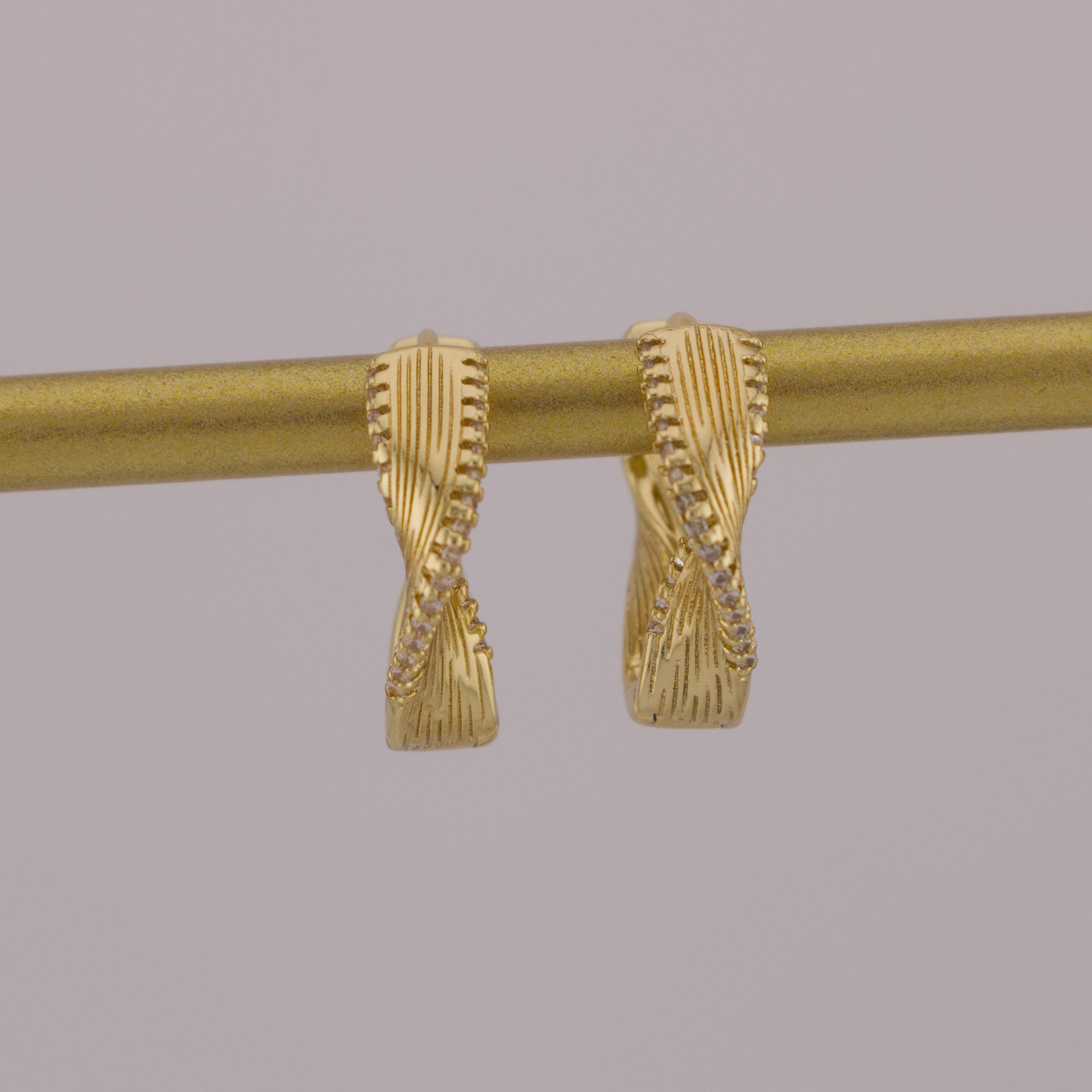 Gold curtain rod with decorative finials on a gray background
