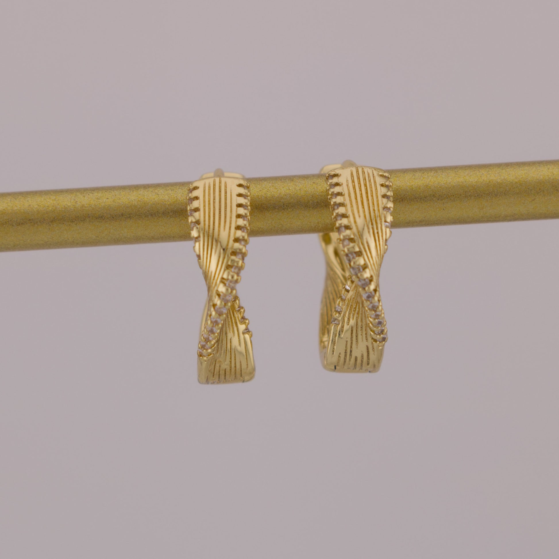 Gold curtain rod with decorative finials on a gray background