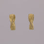 Pair of gold earrings on a gray background