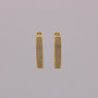 Gold hoop earrings with embedded stones on a gray background
