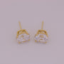 Gold earrings with clear gemstones on a light gray background