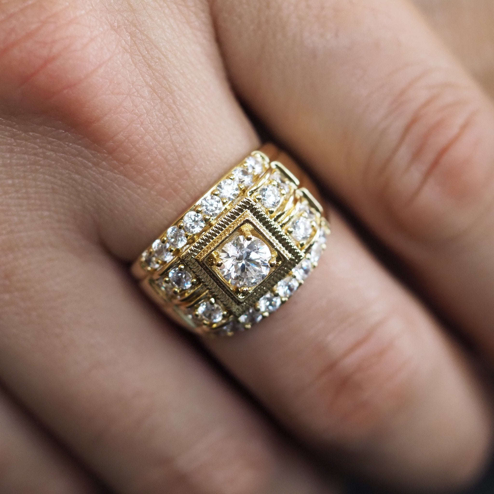 Gold ring with diamonds on a finger