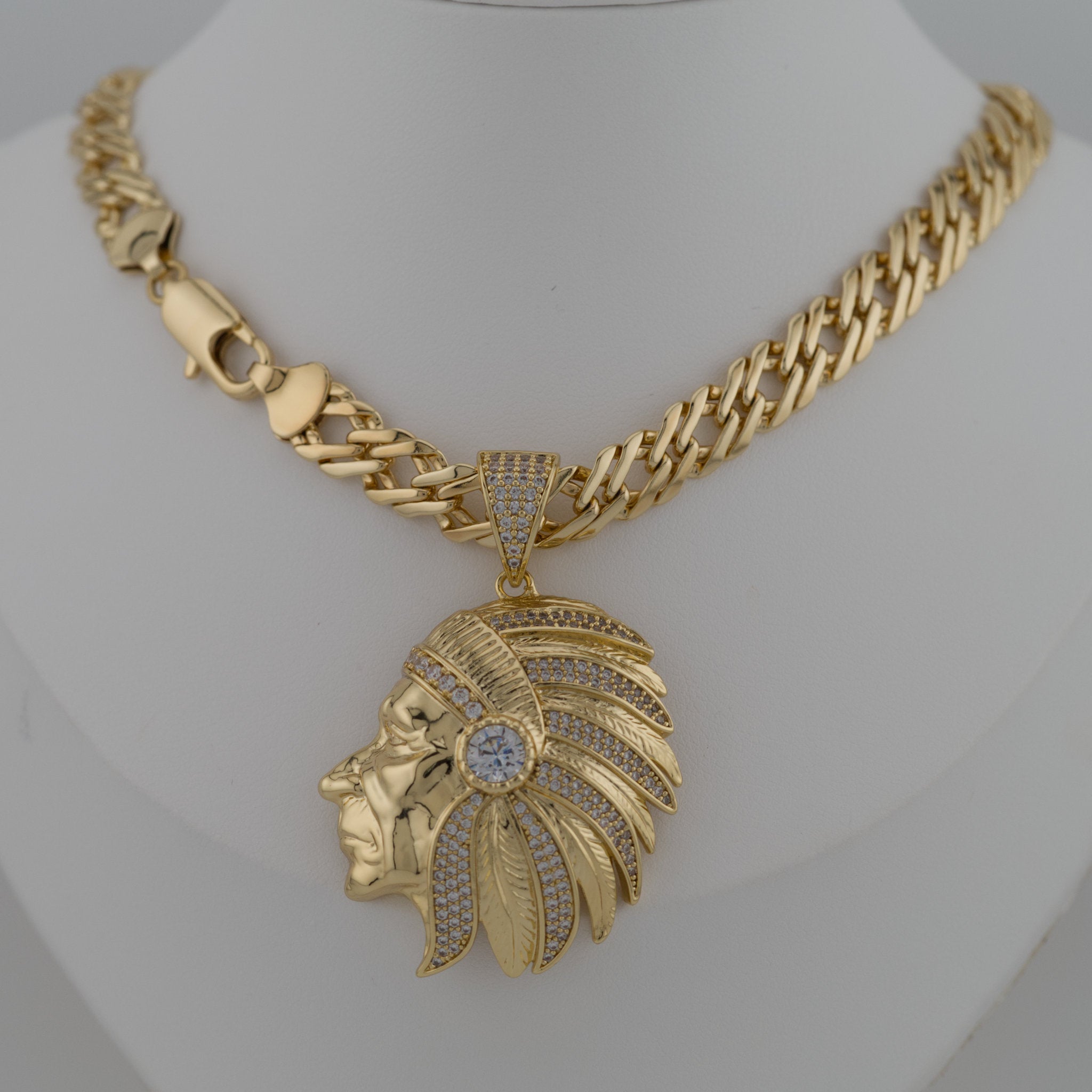 Gold necklace with a Native American headpiece pendant on a white background