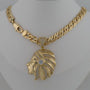 Gold necklace with a Native American headpiece pendant on a white background