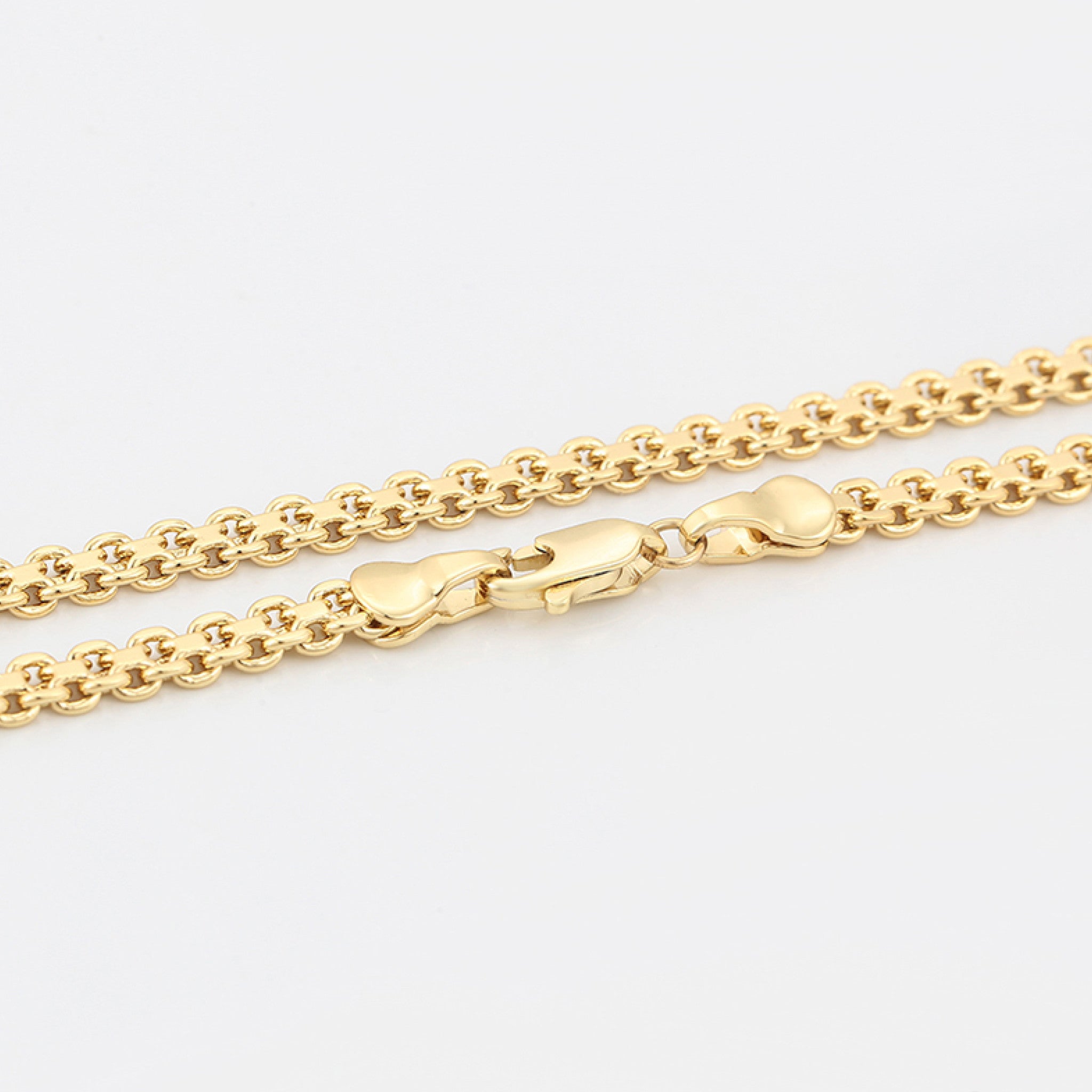 Gold chain necklace on a light gray background