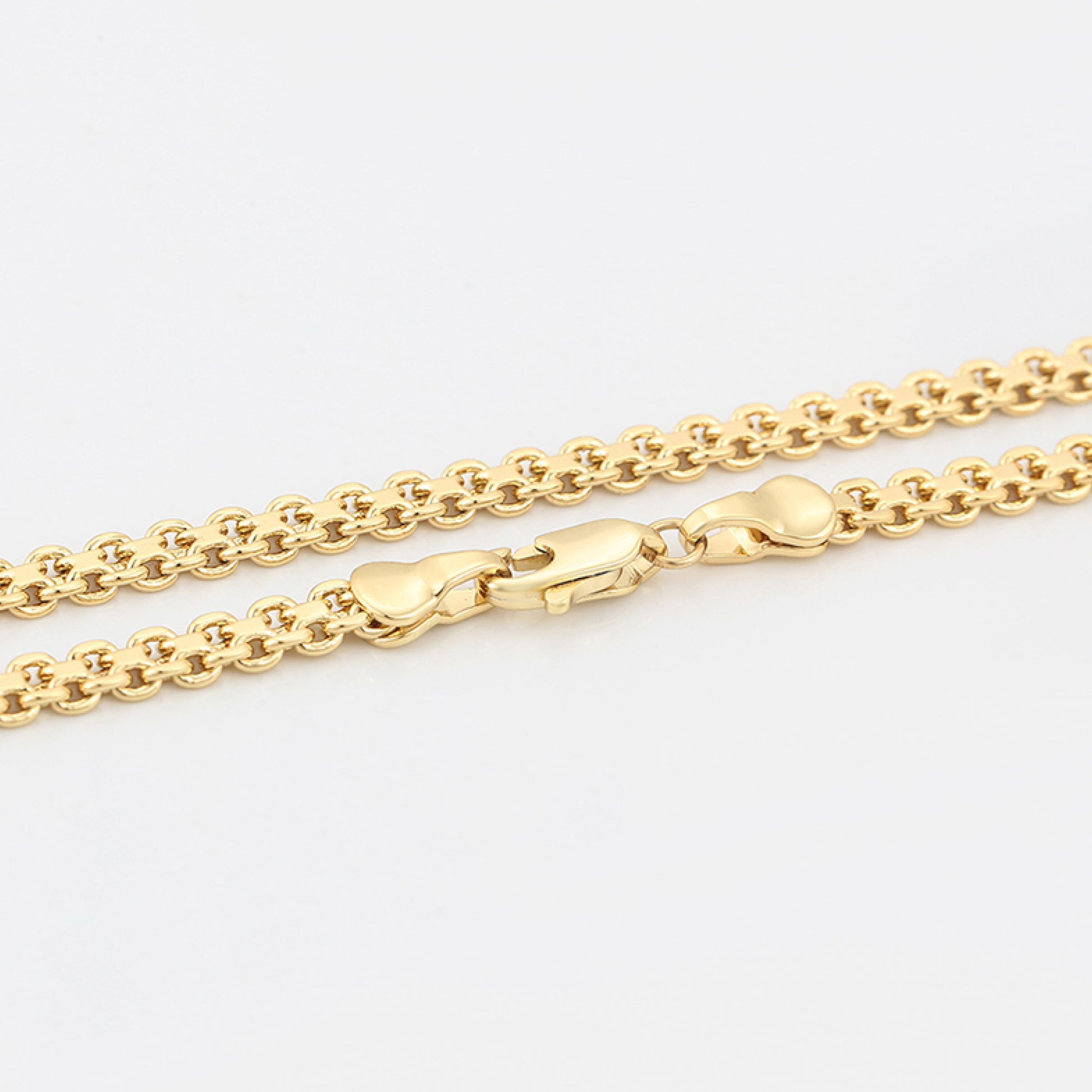 Gold chain necklace on a light gray background