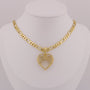 Gold necklace with a heart-shaped pendant on a mannequin bust.