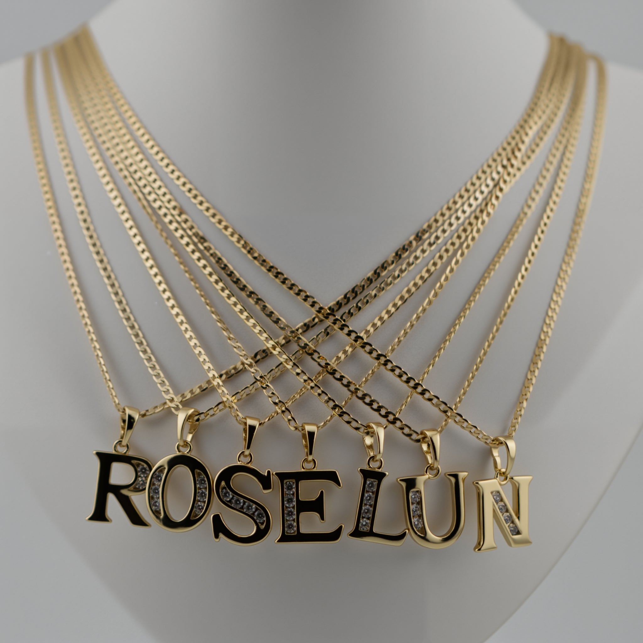 Gold necklaces with 'ROSELUN' pendant on a mannequin