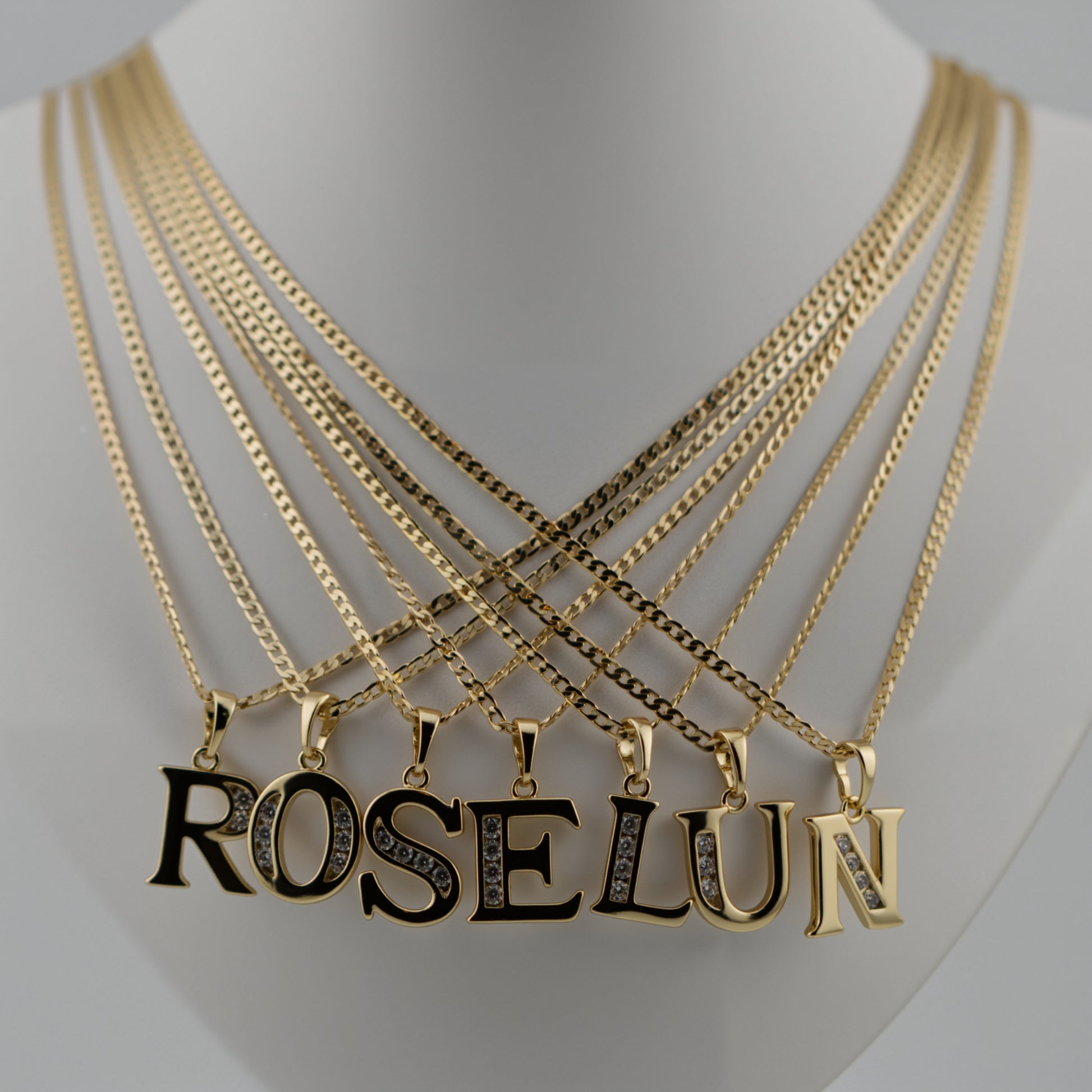 Gold necklaces with 'ROSELUN' pendant on a mannequin