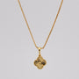 Gold necklace with a pendant on a gray background