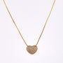 Heart-shaped diamond pendant on a gold chain against a white background