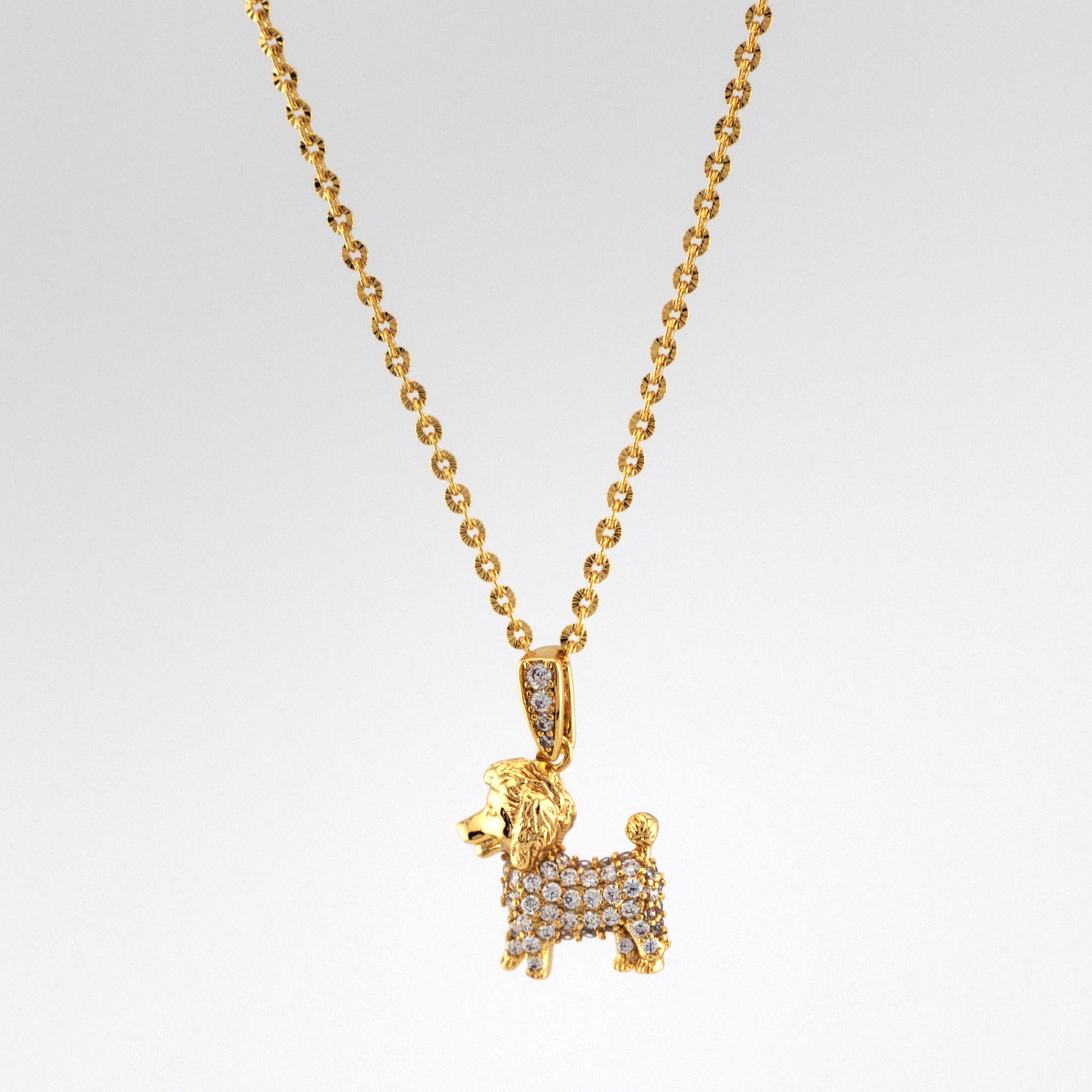 Gold dog-shaped pendant necklace on a light gray background