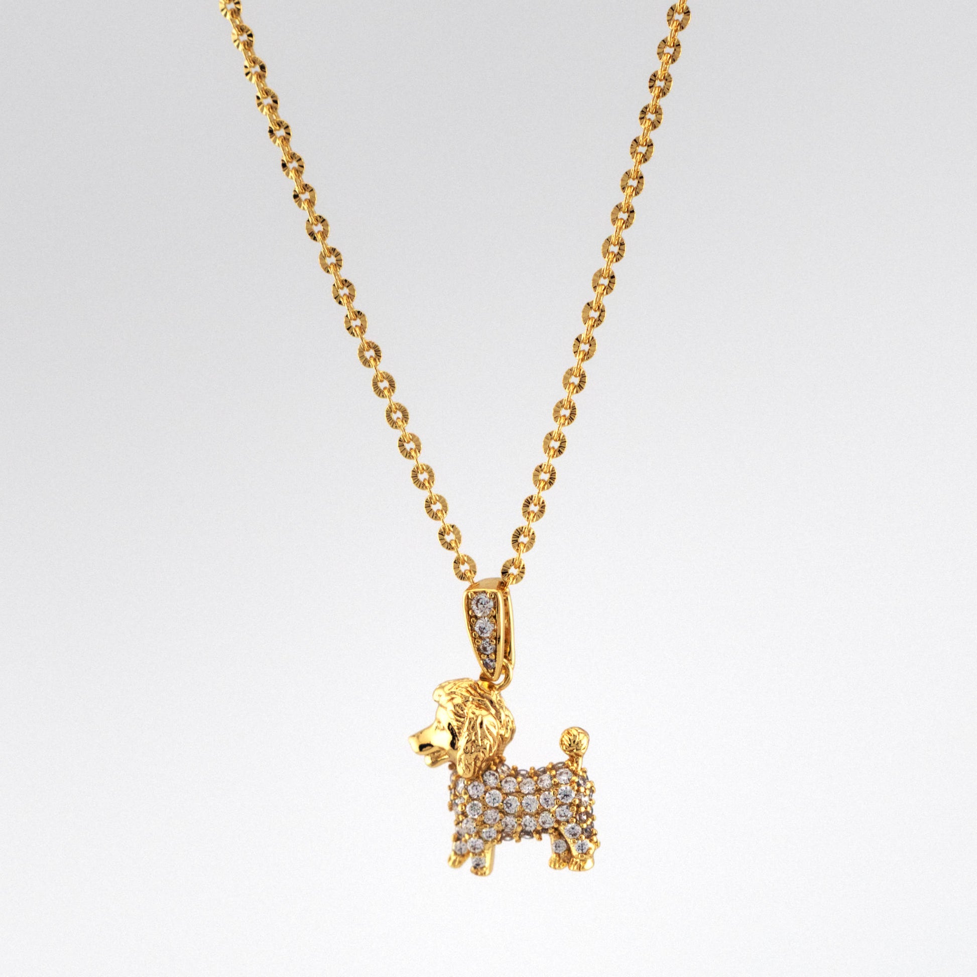 Gold dog-shaped pendant necklace on a light gray background