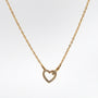 Gold necklace with a heart-shaped pendant on a light gray background