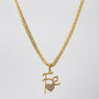 Gold necklace with pendant on a light gray background