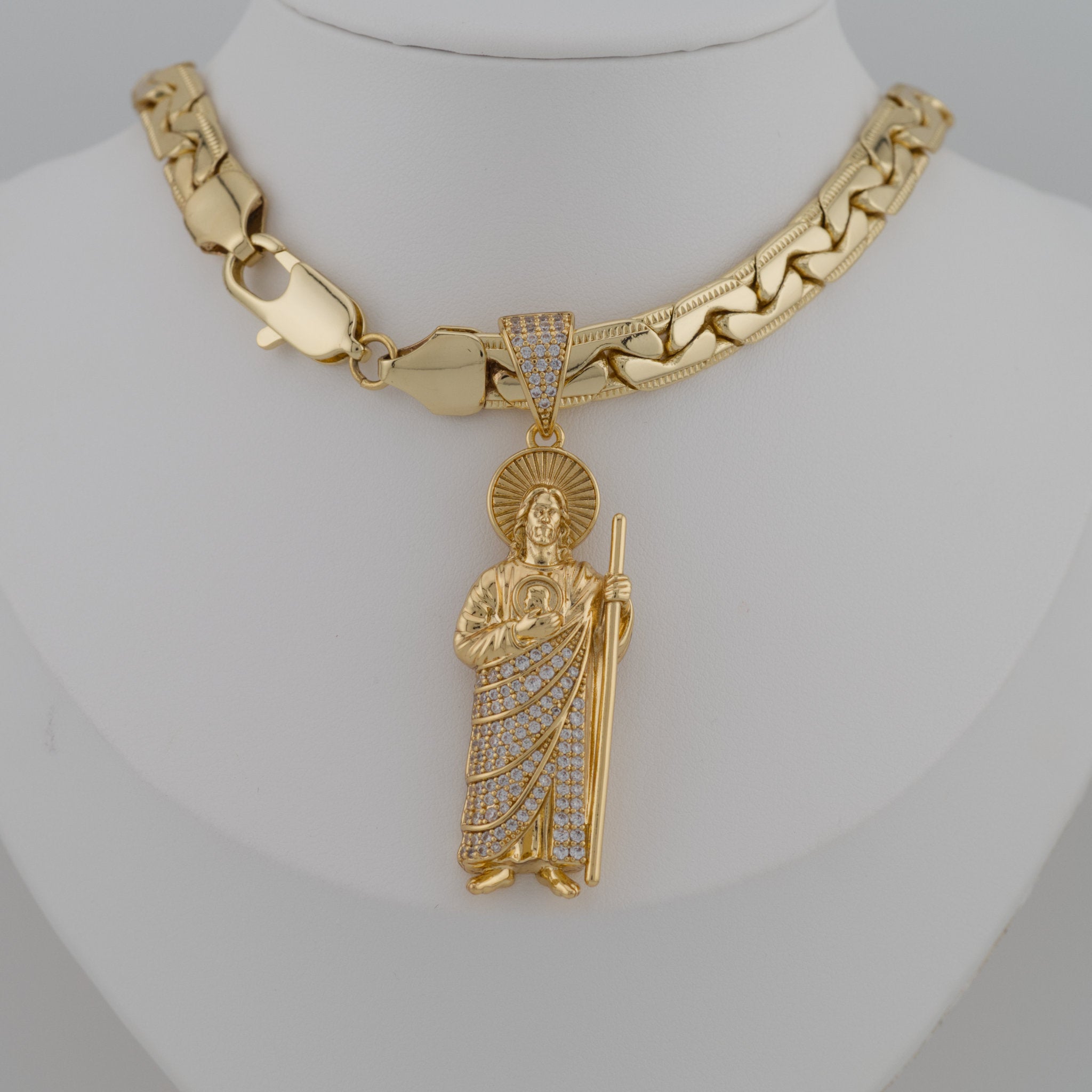 Gold necklace with a detailed pendant on a mannequin neck.