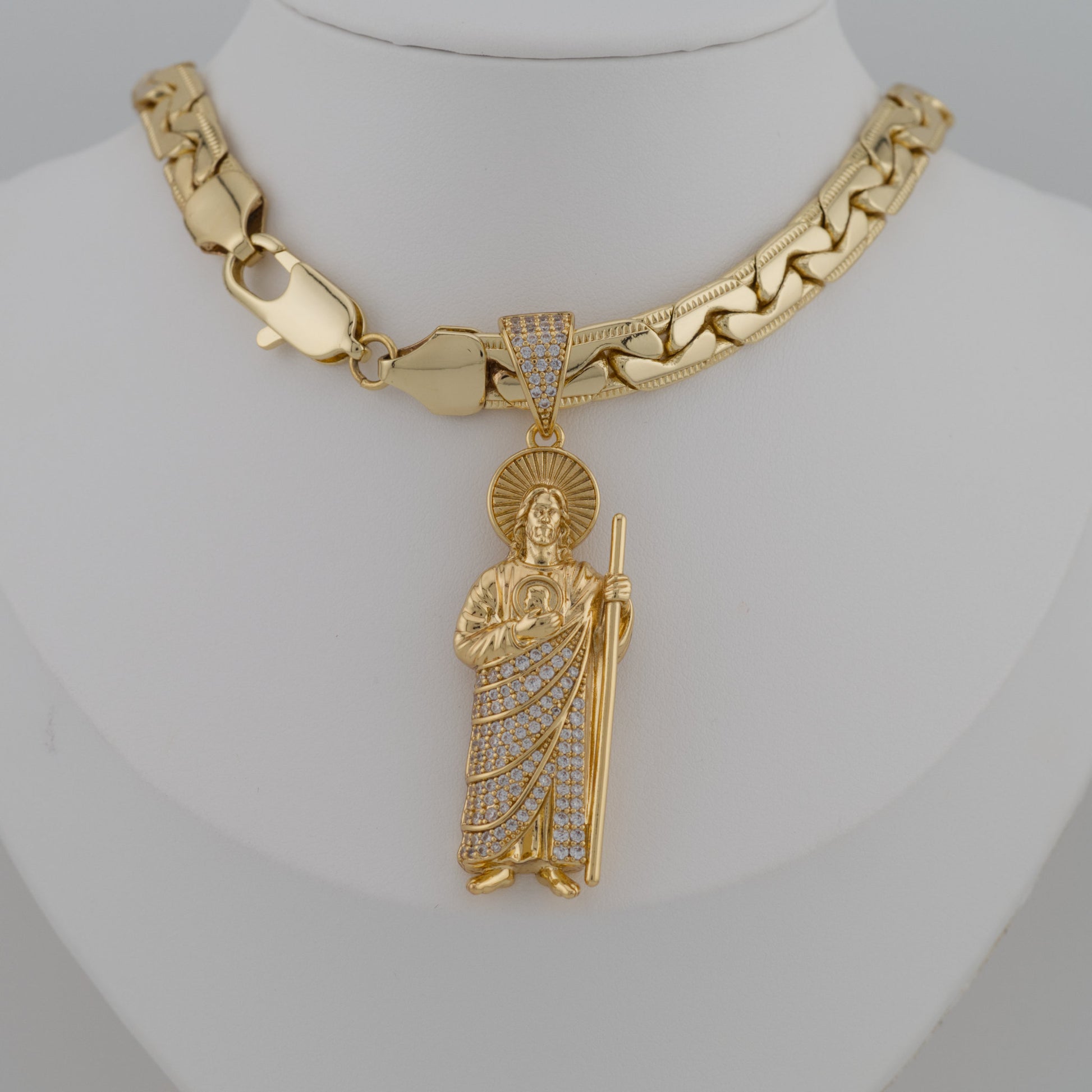 Gold necklace with a detailed pendant on a mannequin neck.