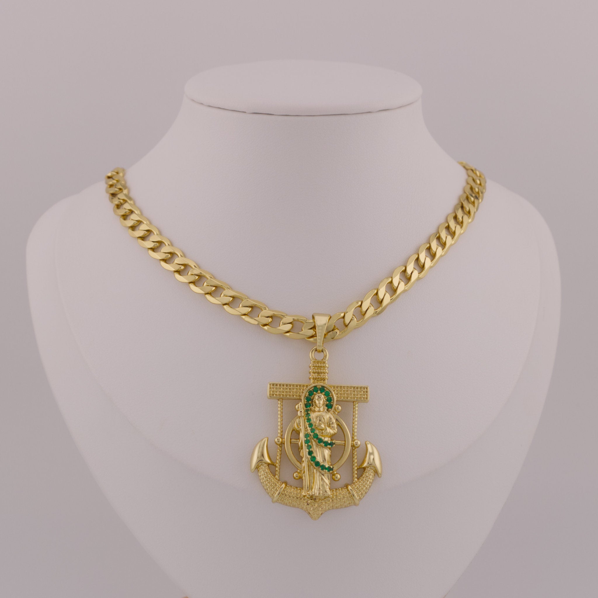 Gold chain necklace with an anchor pendant on a mannequin neck.