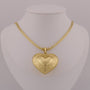 Gold heart-shaped pendant on a mannequin neck with a gray background