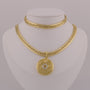 Gold chain necklace with a medallion pendant on a mannequin bust.