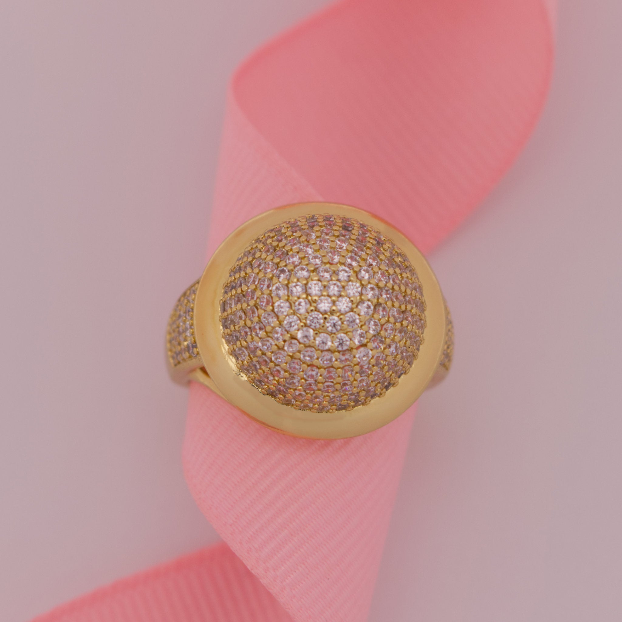 Gold ring with diamonds on a pink ribbon