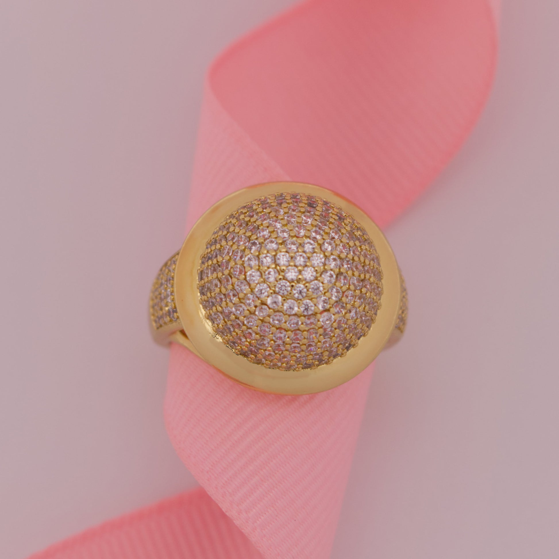 Gold ring with diamonds on a pink ribbon