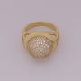 Gold ring with diamond-studded ball on a light gray background