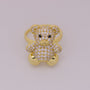 Gold teddy bear-shaped ring with gemstones on a light gray background